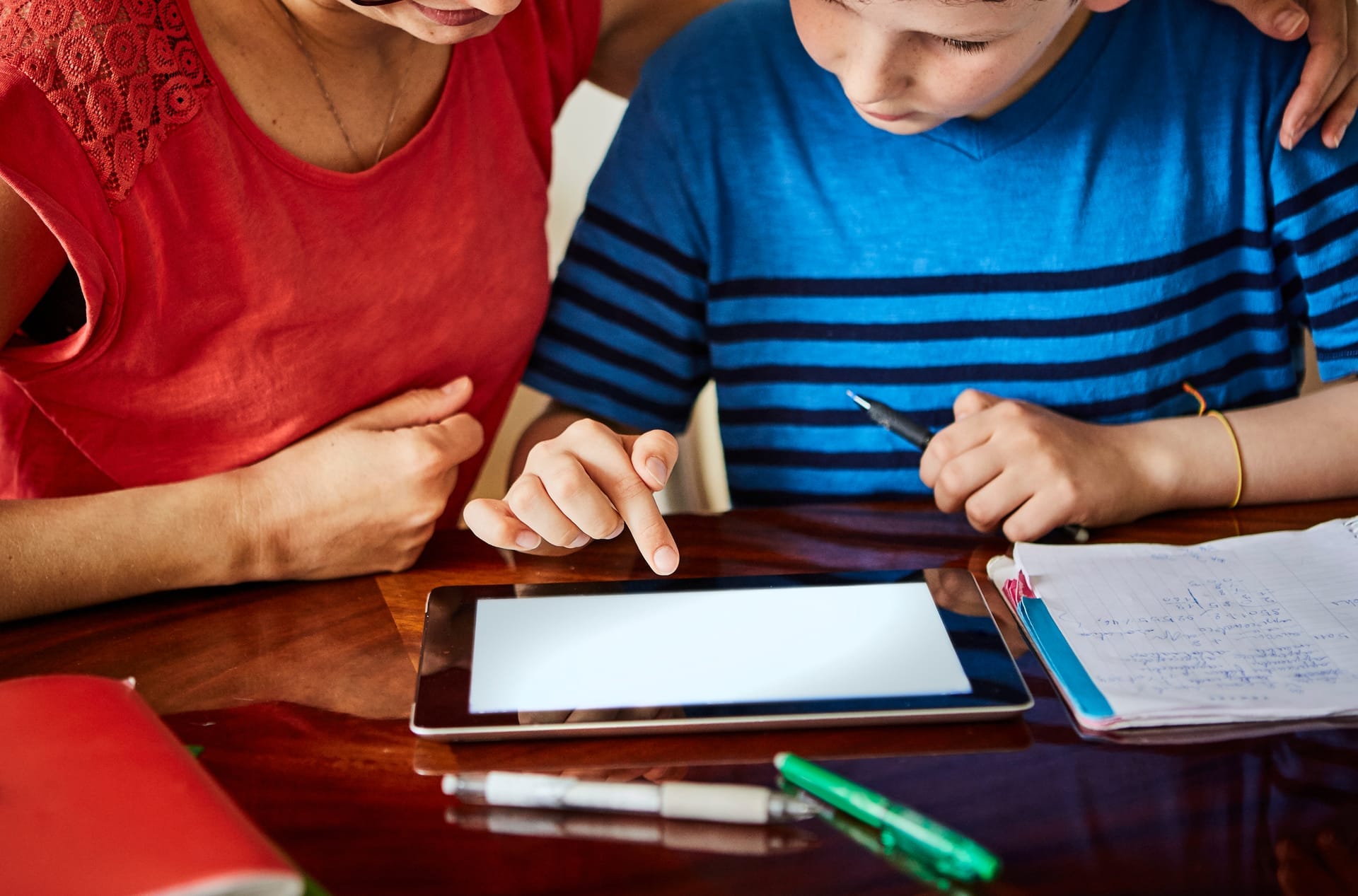 Parent and child reviewing a lesson guide on tablet